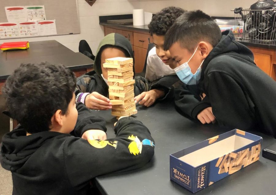 Sixth grade boys challenge each other to Jenga in Mrs. Meltons room.